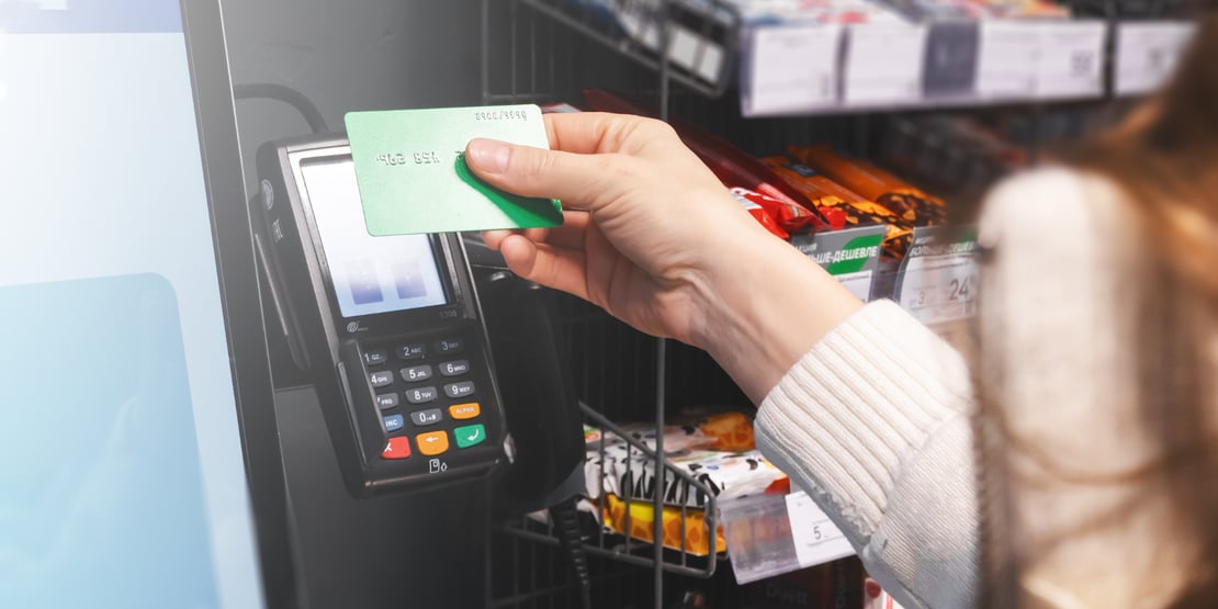 Hand holding a credit card above a POS terminal for secure EMV chip payment, representing POS Level 3 certification requirements.