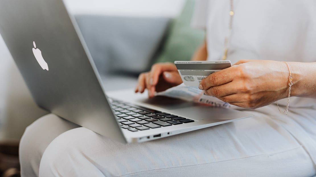 A person using a laptop to purchase something highlighting the importance of choice, consistent experiences, accessibility, and reliable payment infrastructure. 